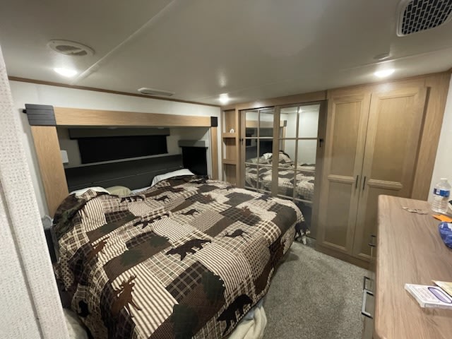 Explore this cozy RV rental bedroom. It features a large bed with a wildlife quilt, mirrored closets, and ample storage.. Prime Time Sanibel 2022