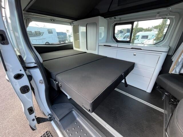 Compact RV rental interior featuring a versatile fold-out bed, clever storage, and bright windows. Perfect for road trips!. URBAN EXPLORER (BOITE AUTOMATIQUE) ADRIA 2023