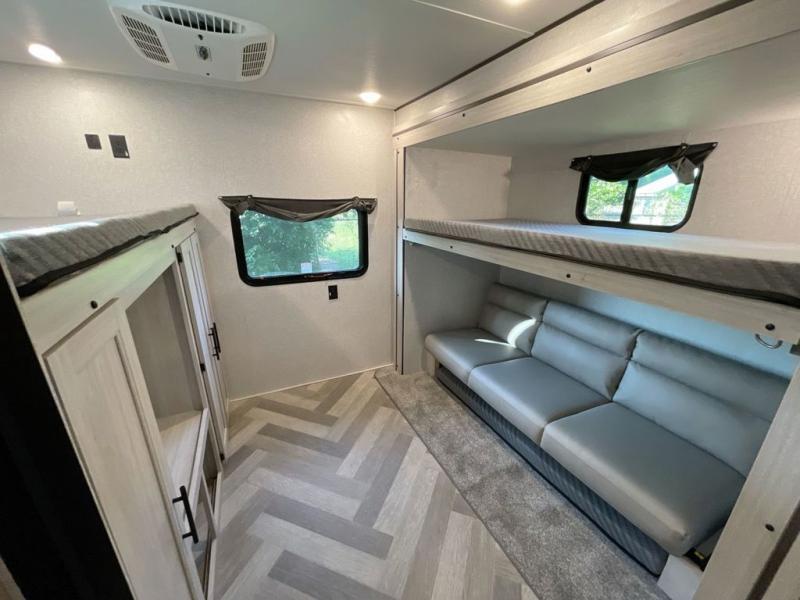 Spacious RV rental interior featuring modern bunk beds, comfortable sofa, and storage. Ideal for family trips.. Crossroads RV Funtime 333sk 2024