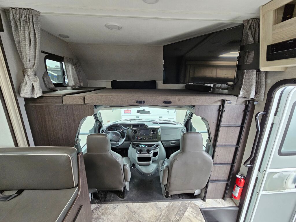 RV rental interior: View of the spacious cabin with overhead bunk, driver's cockpit, and mounted TV.. Forester TS 2020