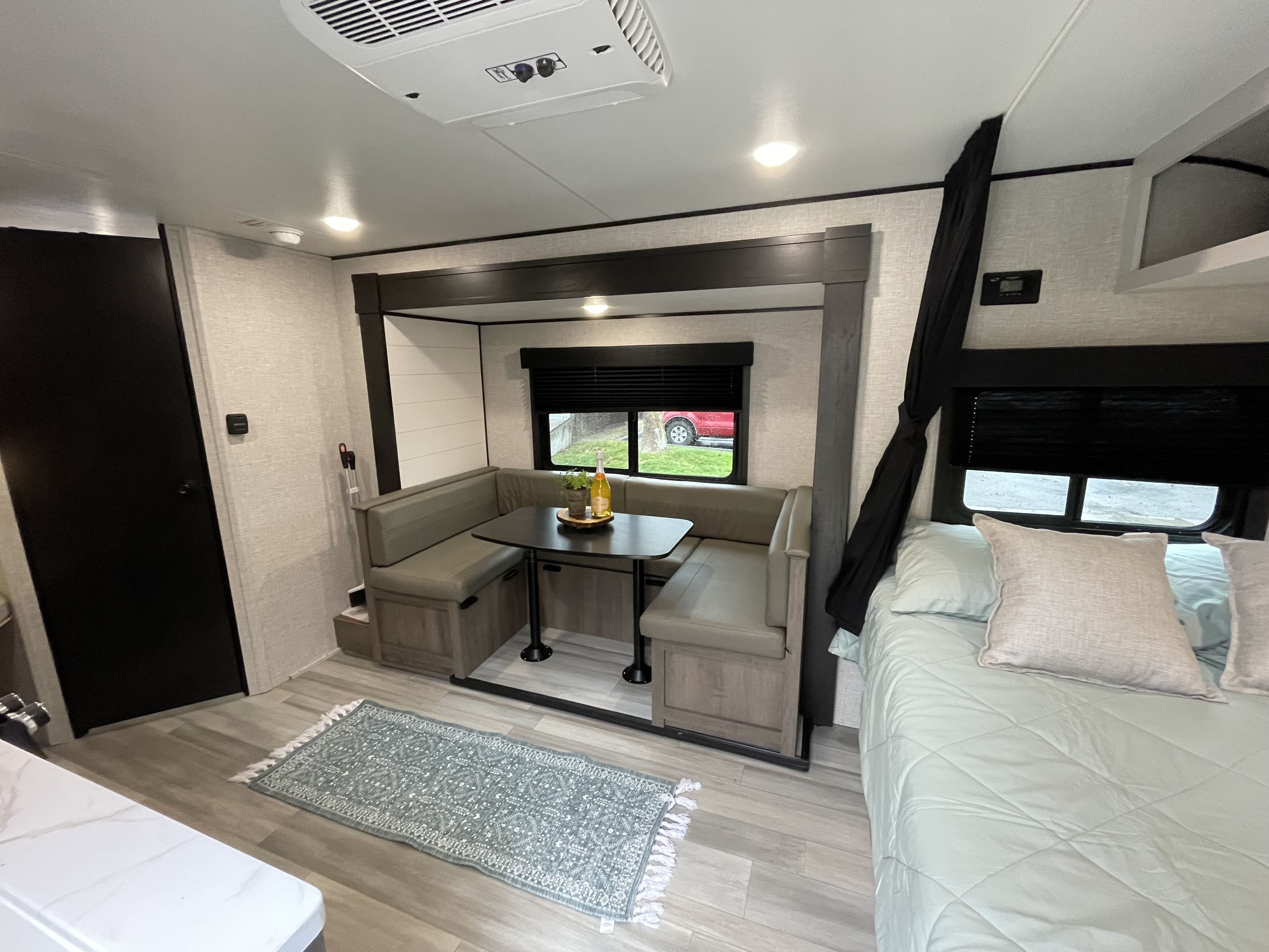 Modern RV rental interior with a cozy dinette, plush bed, and stylish light wood flooring. Perfect for your next trip.. StarCraft 188BHS 2025