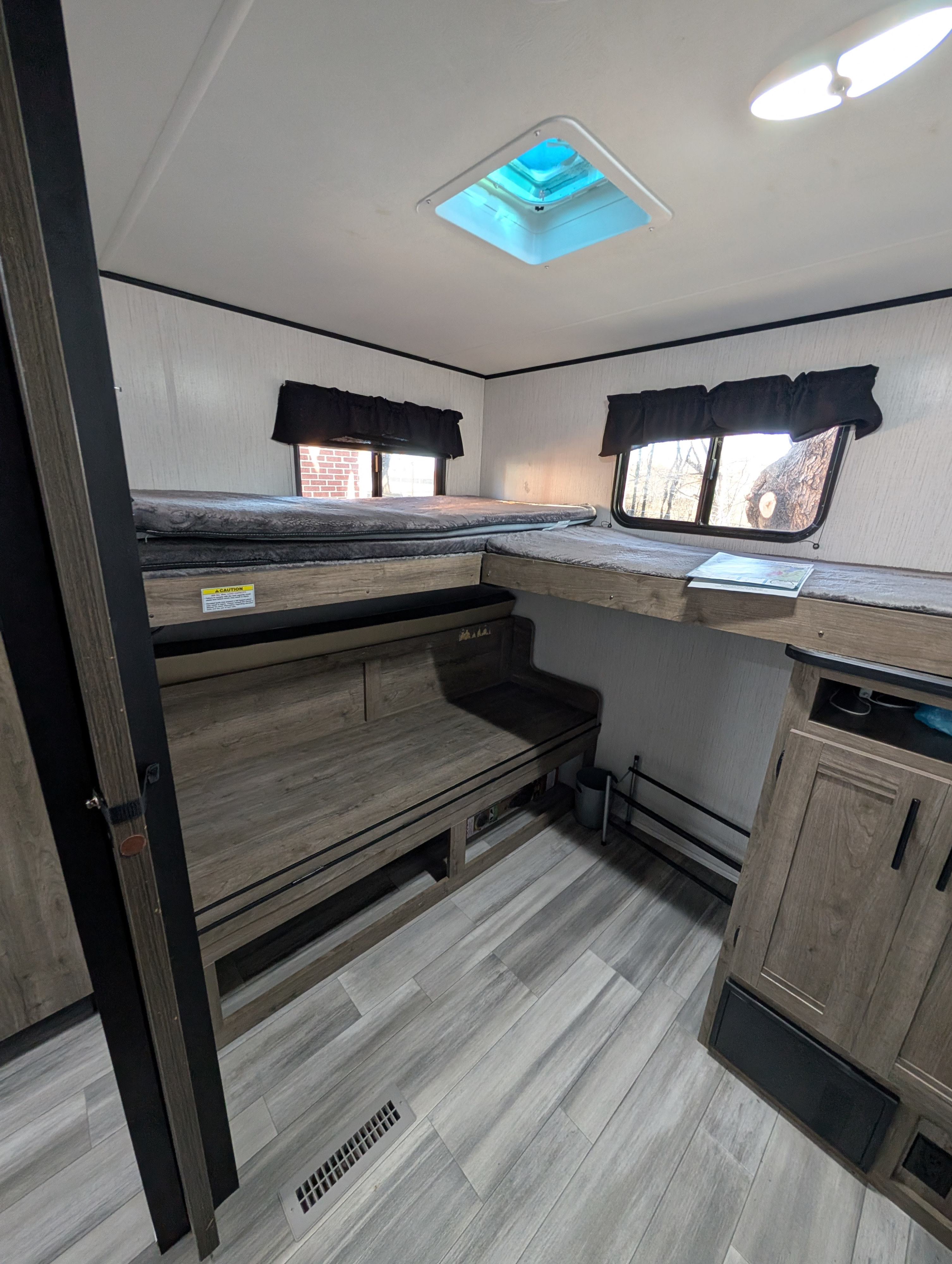 RV rental's spacious interior with multiple bunk beds, skylight, and light wood flooring for comfortable travel.. Heartland RVs Pioneer 2021