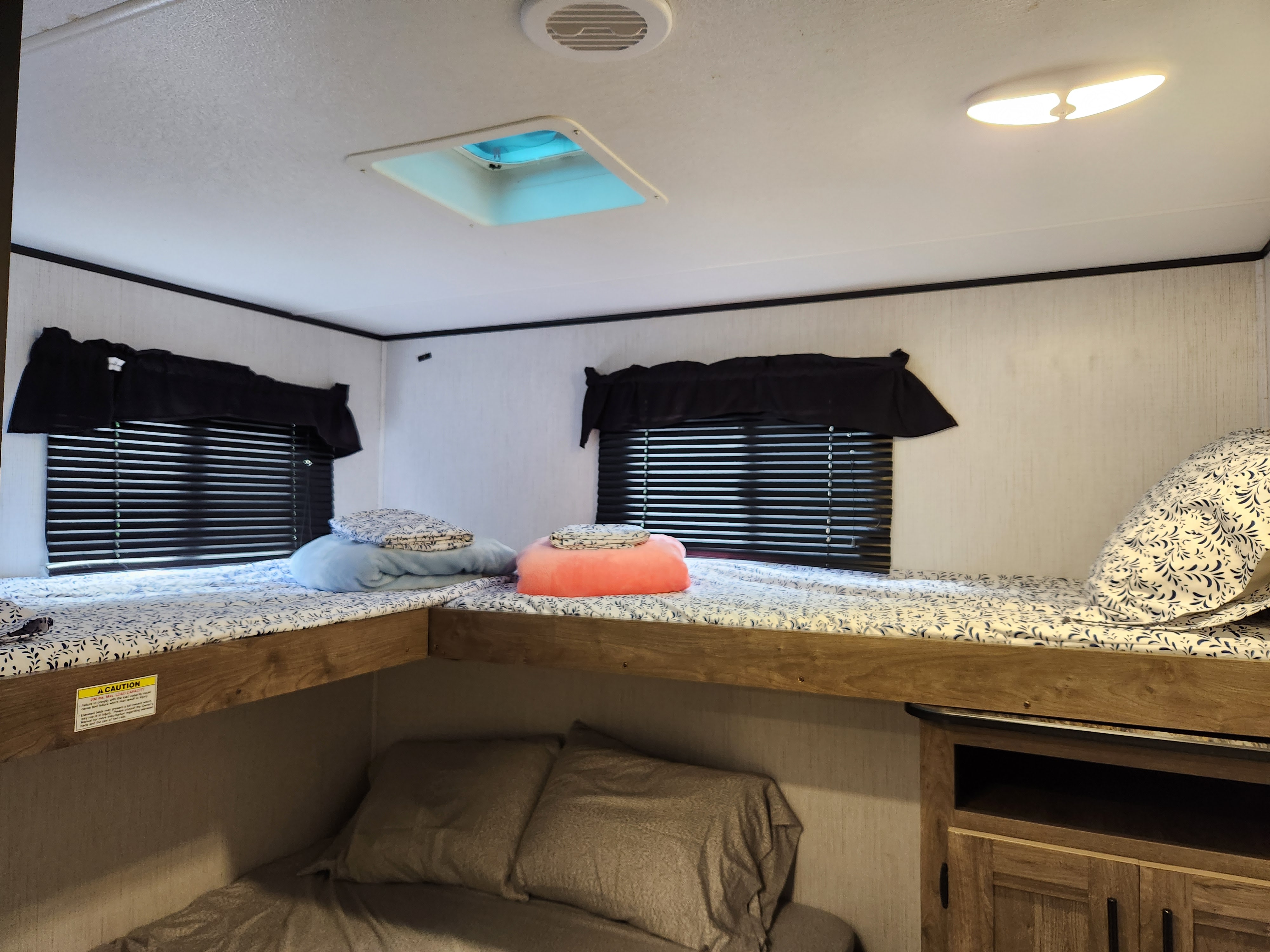Inside an rv rental: functional bunk beds with windows, blinds, soft pillows, and built-in storage space.. Heartland Pioneer 2022