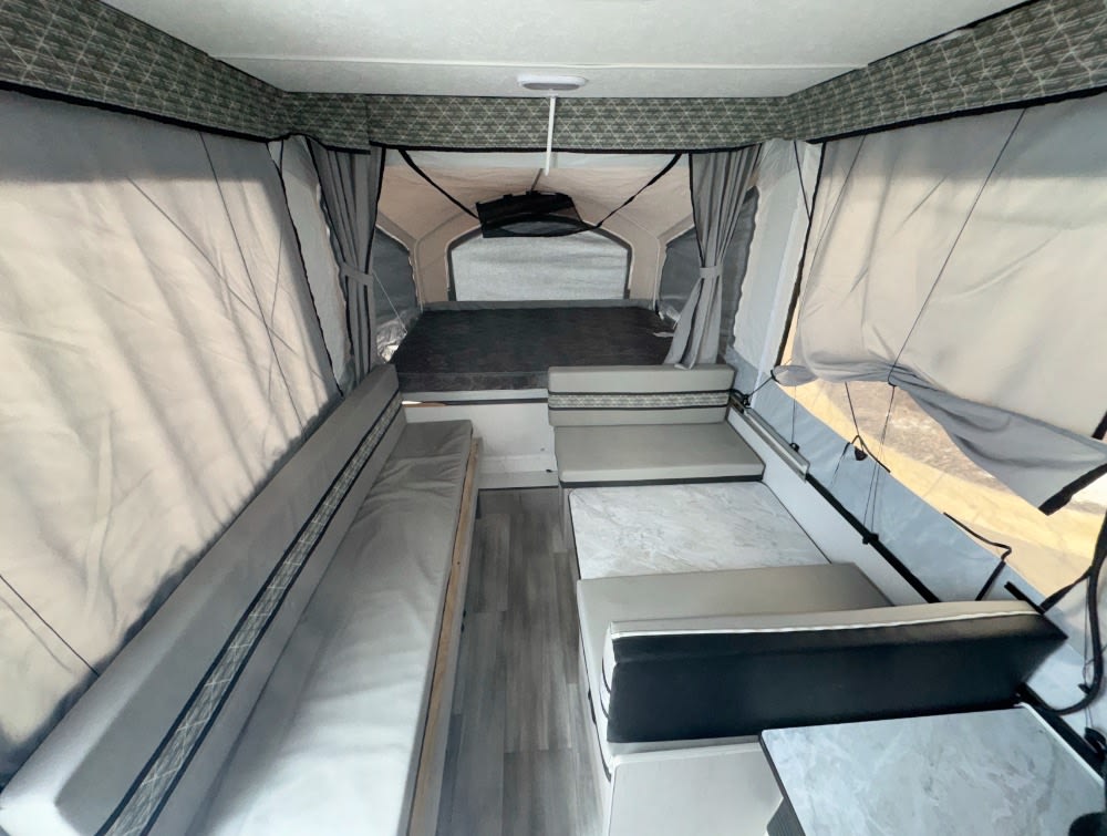 Spacious pop-up camper interior, perfect for your next RV rental adventure. Features bed, dinette & seating.. Viking 2108st 2023