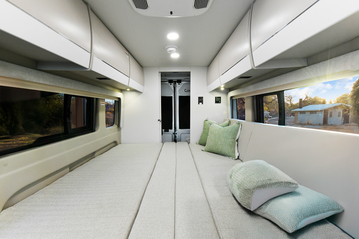 Spacious camper van interior for your next rv rental adventure. Features comfortable bed/seating and overhead storage.. Entegra Coach Ethos 2024