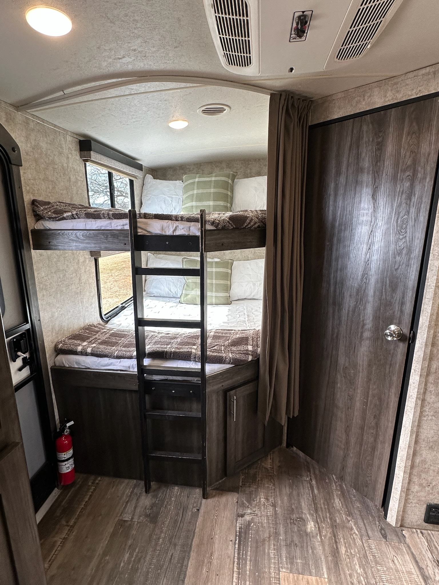 Comfortable RV rental bunk beds, complete with cozy bedding, window, and fire extinguisher for safe travels.. Highland Ridge RV Mesa Ridge Lite 2018