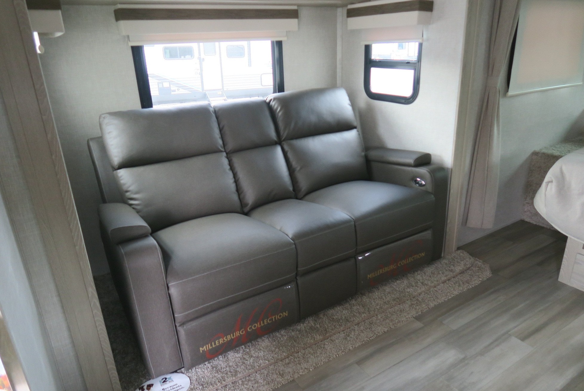Spacious RV rental living area featuring a comfortable gray reclining sofa, large windows, and modern finishes.. Forest River Rockwood Mini Lite 2022