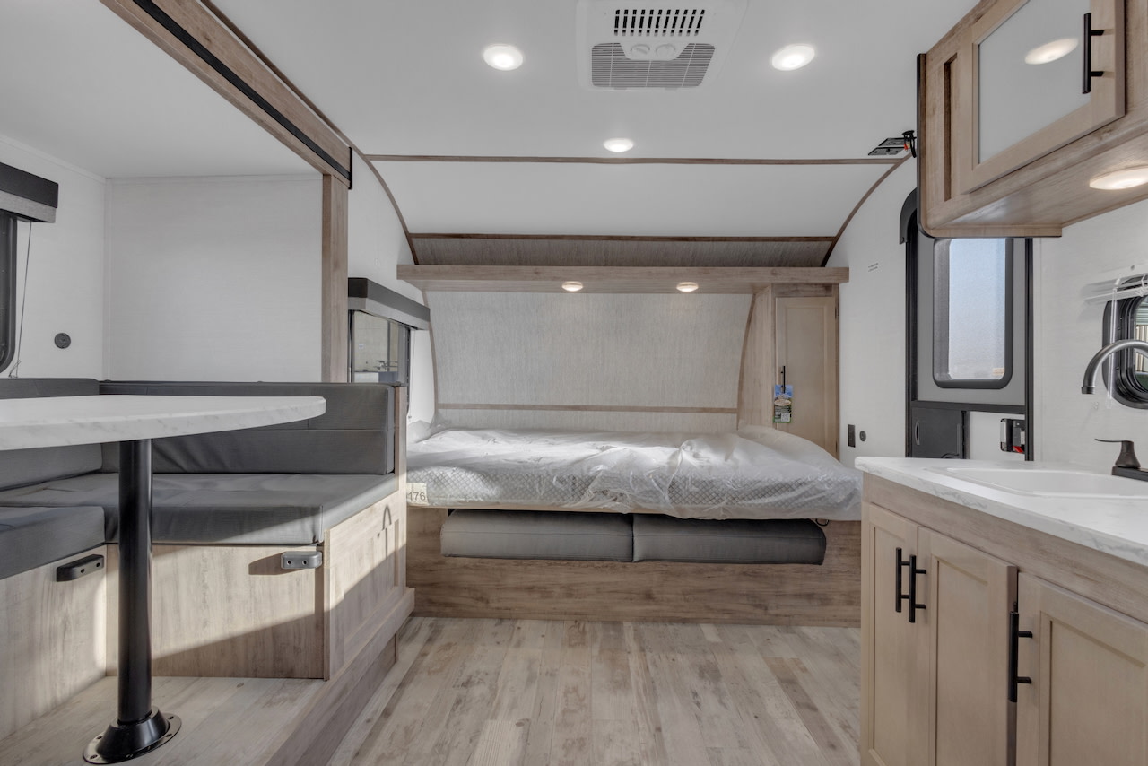Modern RV rental interior with bed, dinette, and kitchen. A comfortable camper living space for travel.. Gulf Stream Kingsport 192DS 2025