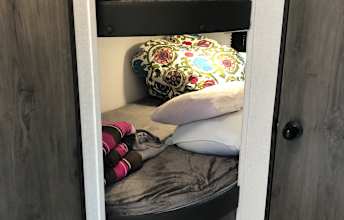 Cozy bunk beds in an RV rental, complete with colorful patterned pillows and soft bedding, offer family-friendly sleeping.. Coachmen Clipper 2022