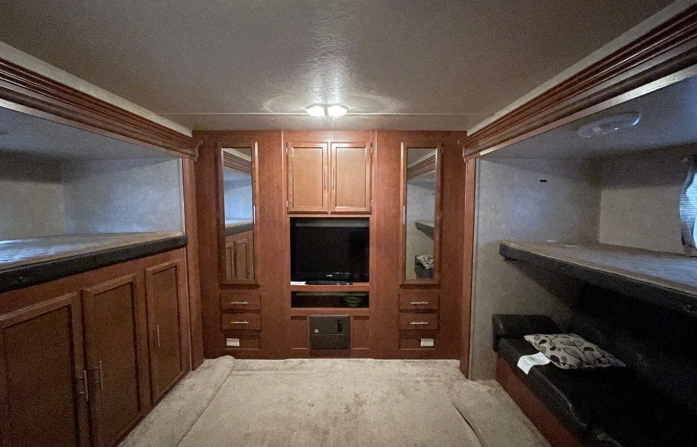 Spacious RV rental interior with bunk beds, an entertainment center, and warm wood finishes.. Forest River Salem 2014