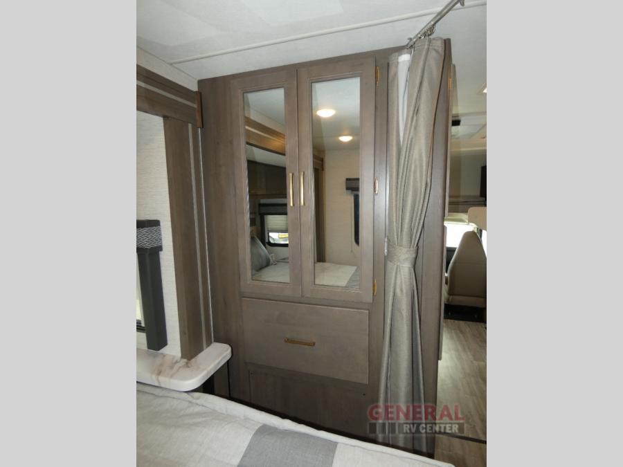 RV rental: Bedroom area with mirrored wardrobe, providing storage and a privacy curtain. Ideal for compact living.. Thor Motor Coach Four Winds 22B 2025