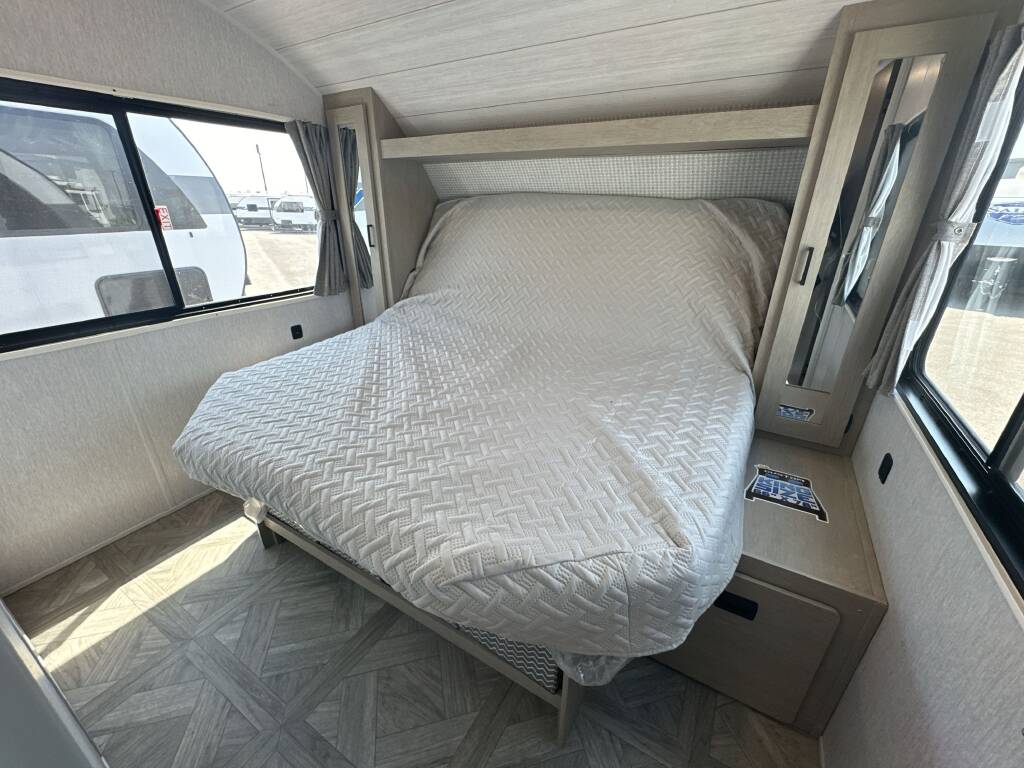 Cozy RV rental bedroom featuring a comfortable bed, window views, and integrated storage, perfect for your next trip.. Forest River Salem Cruise Lite 2024