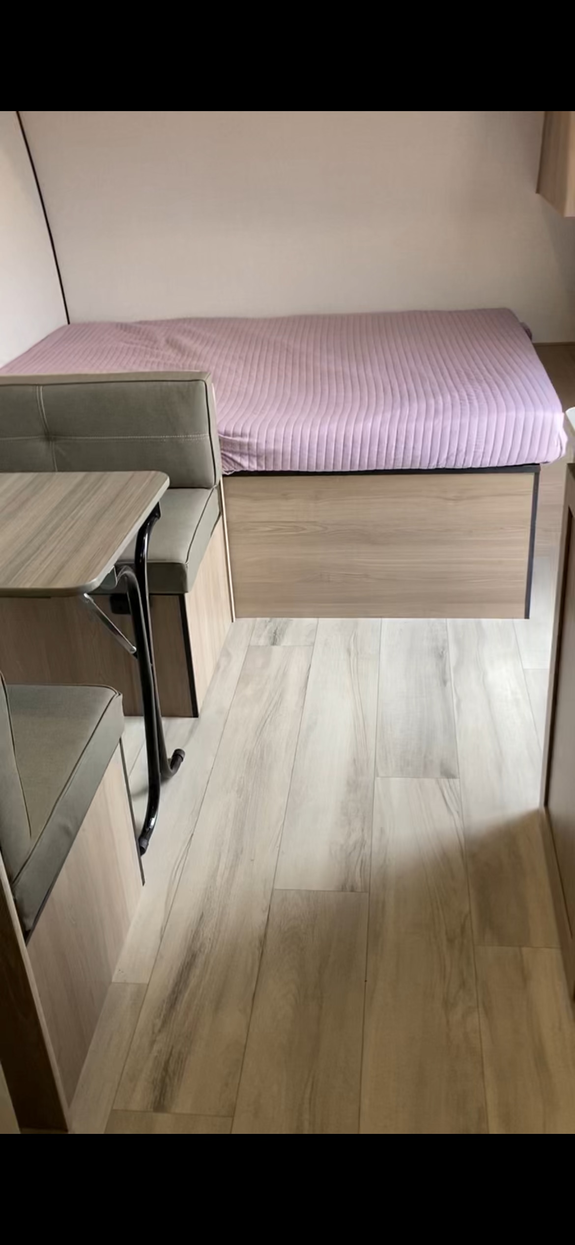 RV rental interior: light wood flooring, grey dinette, and cozy bed with pink cover. Compact and functional space.. 4YDTCMG17SM936605 17B 2025