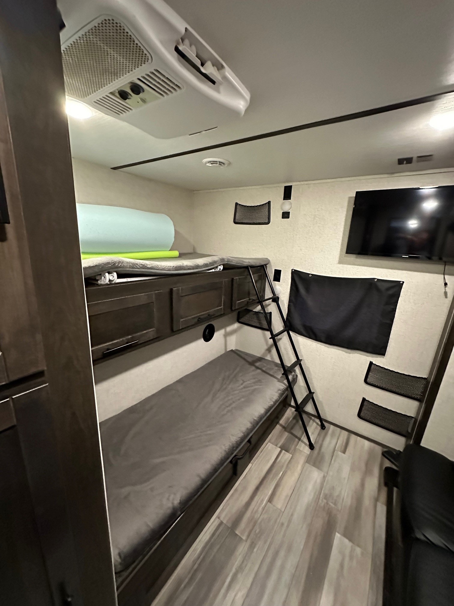 Cozy RV rental interior with bunk beds, TV, and AC unit. Perfect for road trips and family travel adventures.. Crossroads RV Cruiser Aire 2022