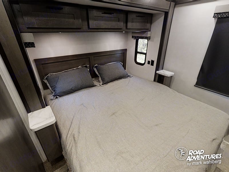 This RV rental offers a compact bedroom with a queen bed, overhead storage, and integrated nightstands.. Forest River Fr3 2025