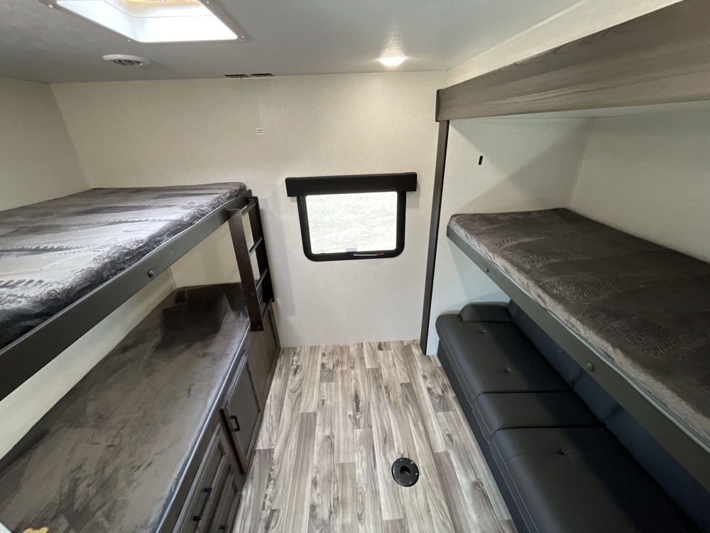 RV rental interior featuring comfortable bunk beds, a sofa, and integrated storage, perfect for family trips.. Venture 327VIK 2024
