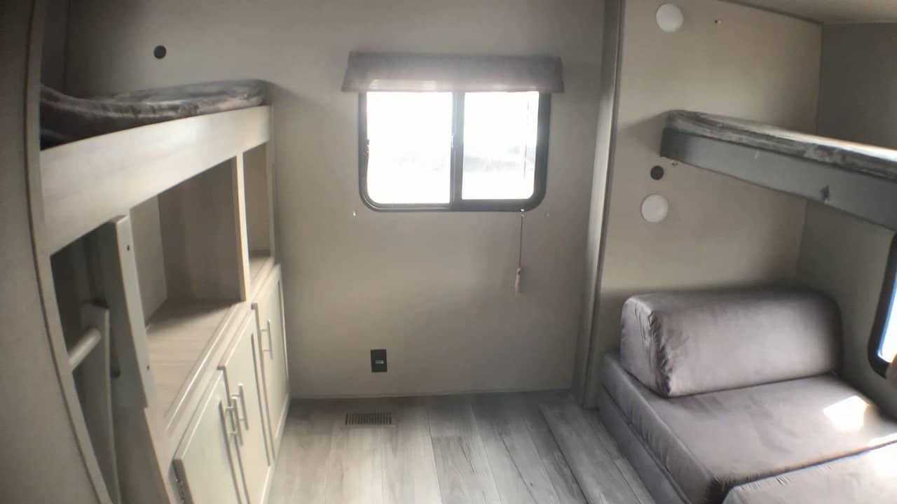 RV rental interior: bunk beds, a pull-out couch, storage shelving, and a bright window for comfortable travel.. Coachmen Catalina 2024
