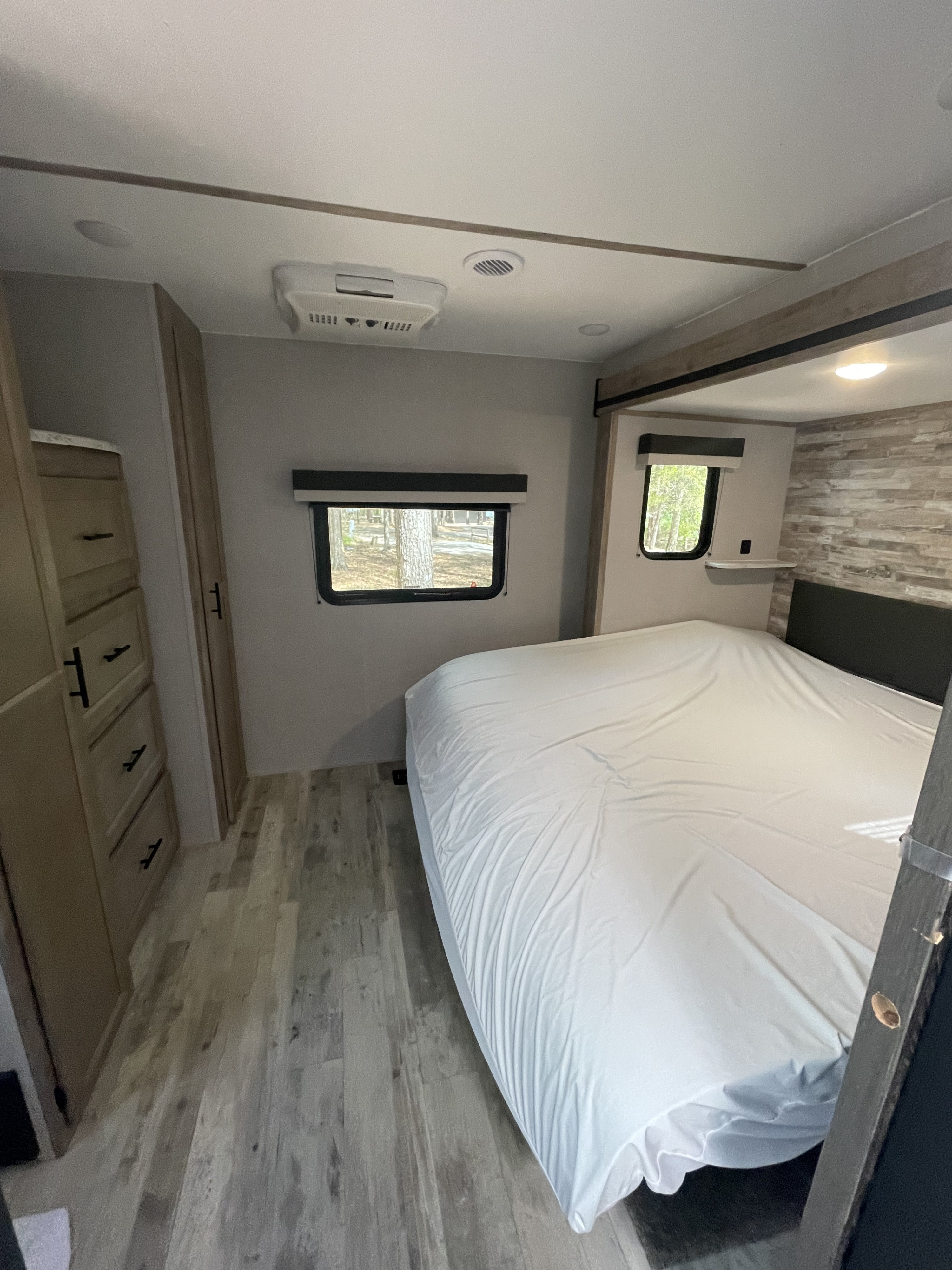 Bright RV rental bedroom: modern design, crisp white bed, ample storage, and scenic windows.. Gulf Stream Innsbruck 2023