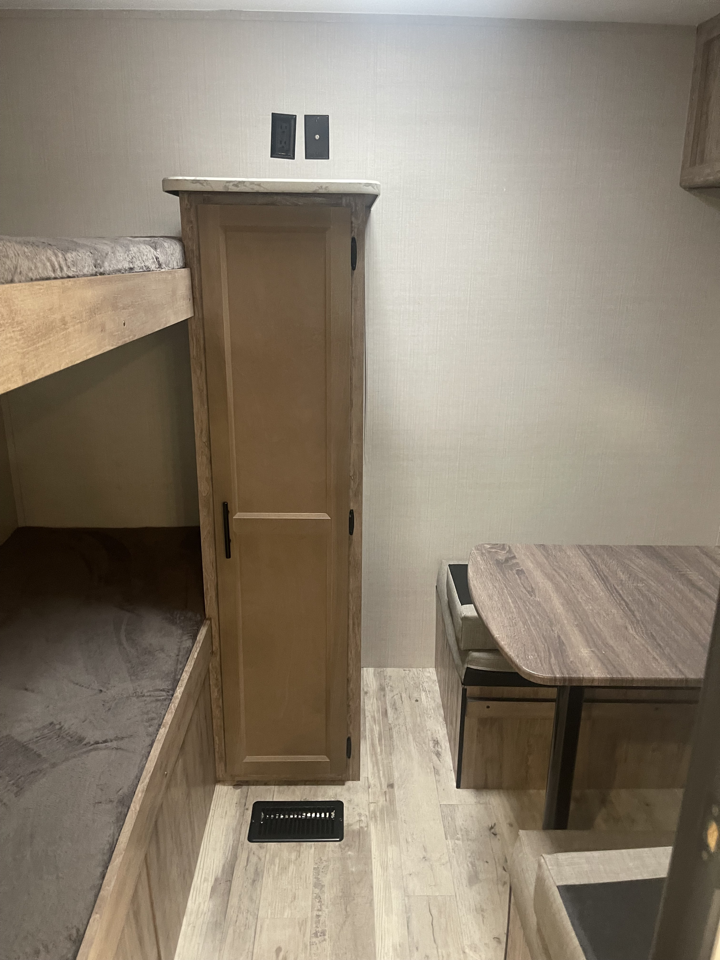 RV rental: Compact interior showing bunk beds, a narrow closet, and a dinette with upholstered bench seating on light wood flooring.. Gulf Stream Innsbruck 2023