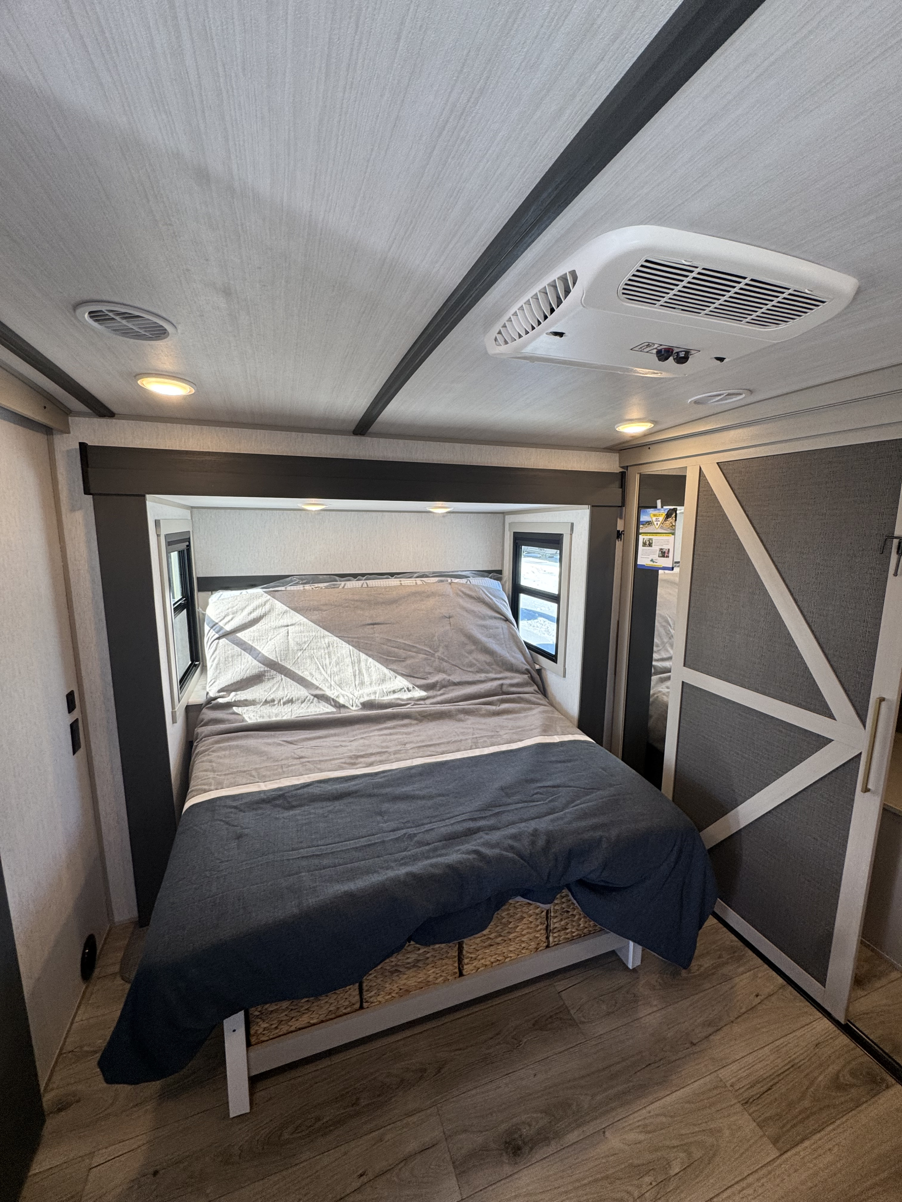 This RV rental shows a cozy, modern bedroom with AC, a comfortable bed, and wood floors, perfect for travel.. Forest River Salem Hemisphere 2024