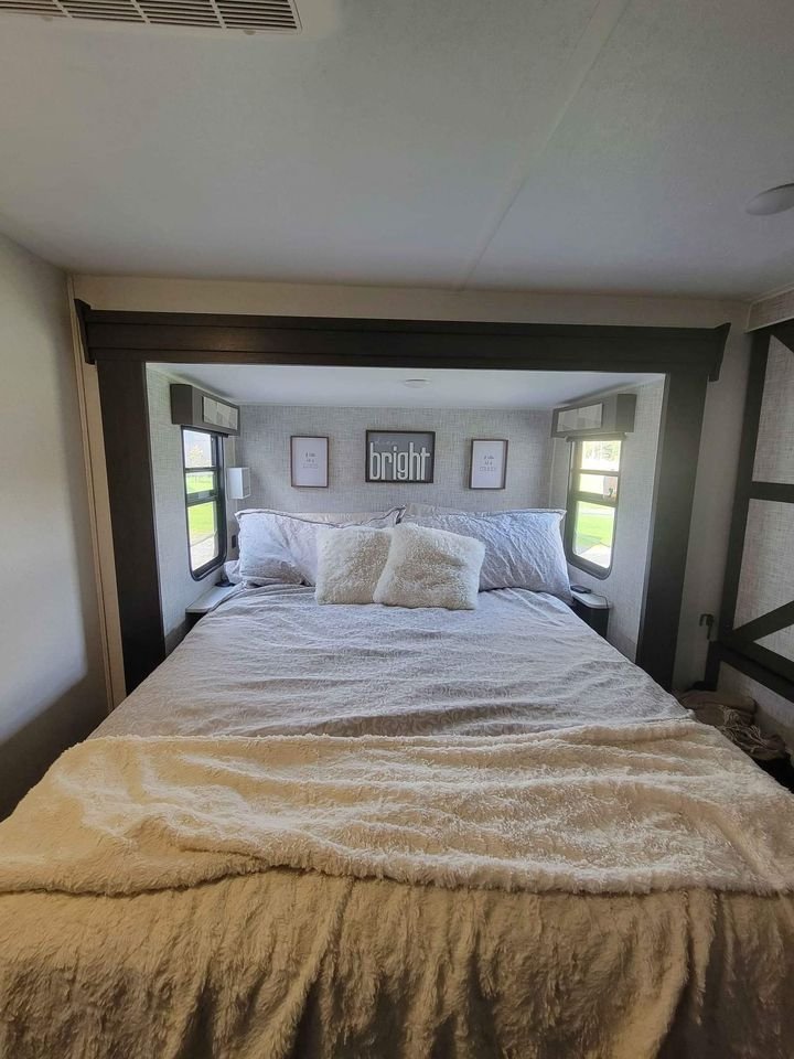 Experience comfort in this RV rental bedroom: a cozy queen bed with side windows, fuzzy blankets, and a 'bright' decor.. Forest River Salem 2018