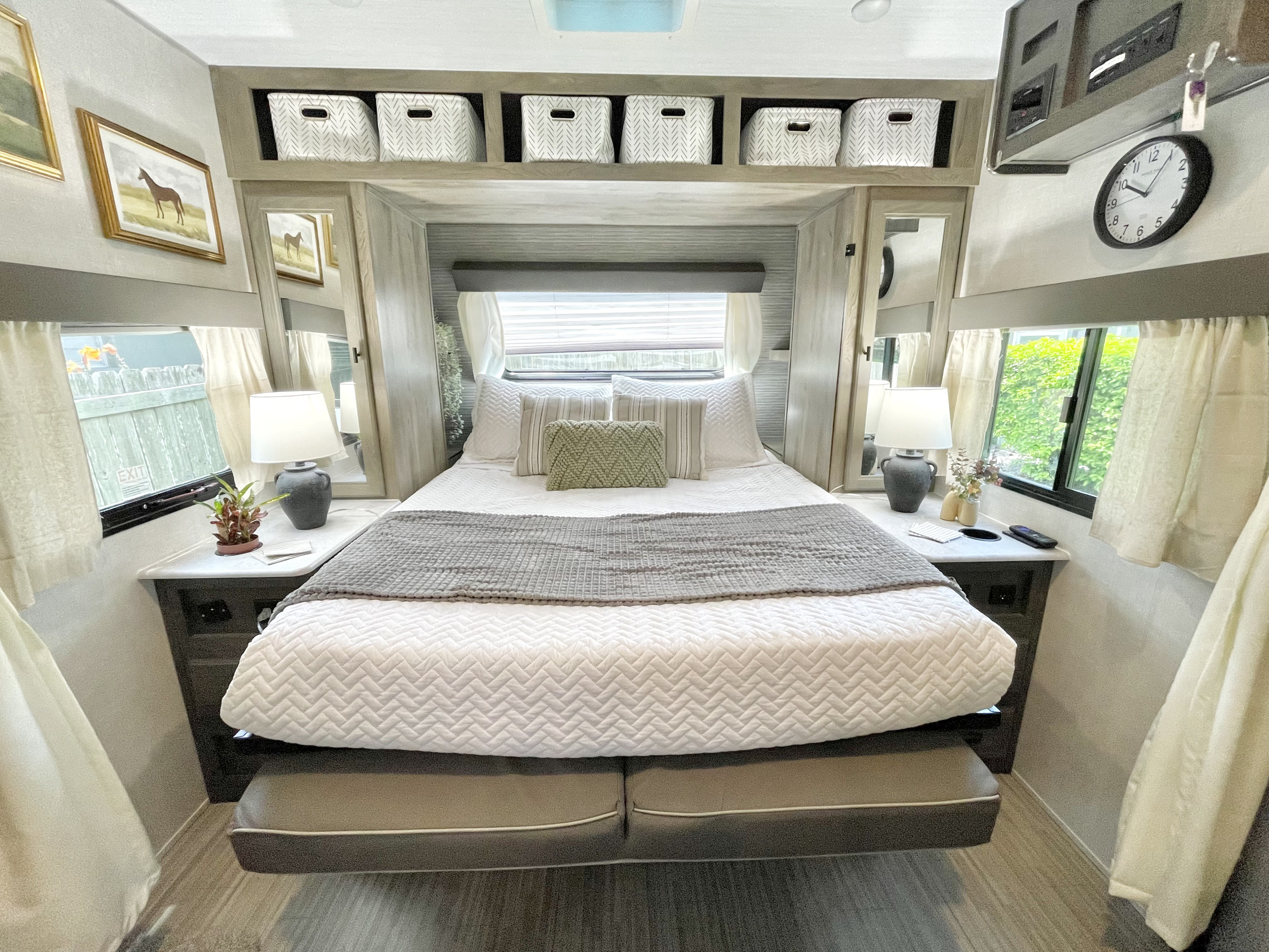 Experience comfort in this stylish RV rental bedroom, featuring a queen bed, storage bins, and bright windows.. Forest River Surveyor Legend 2021