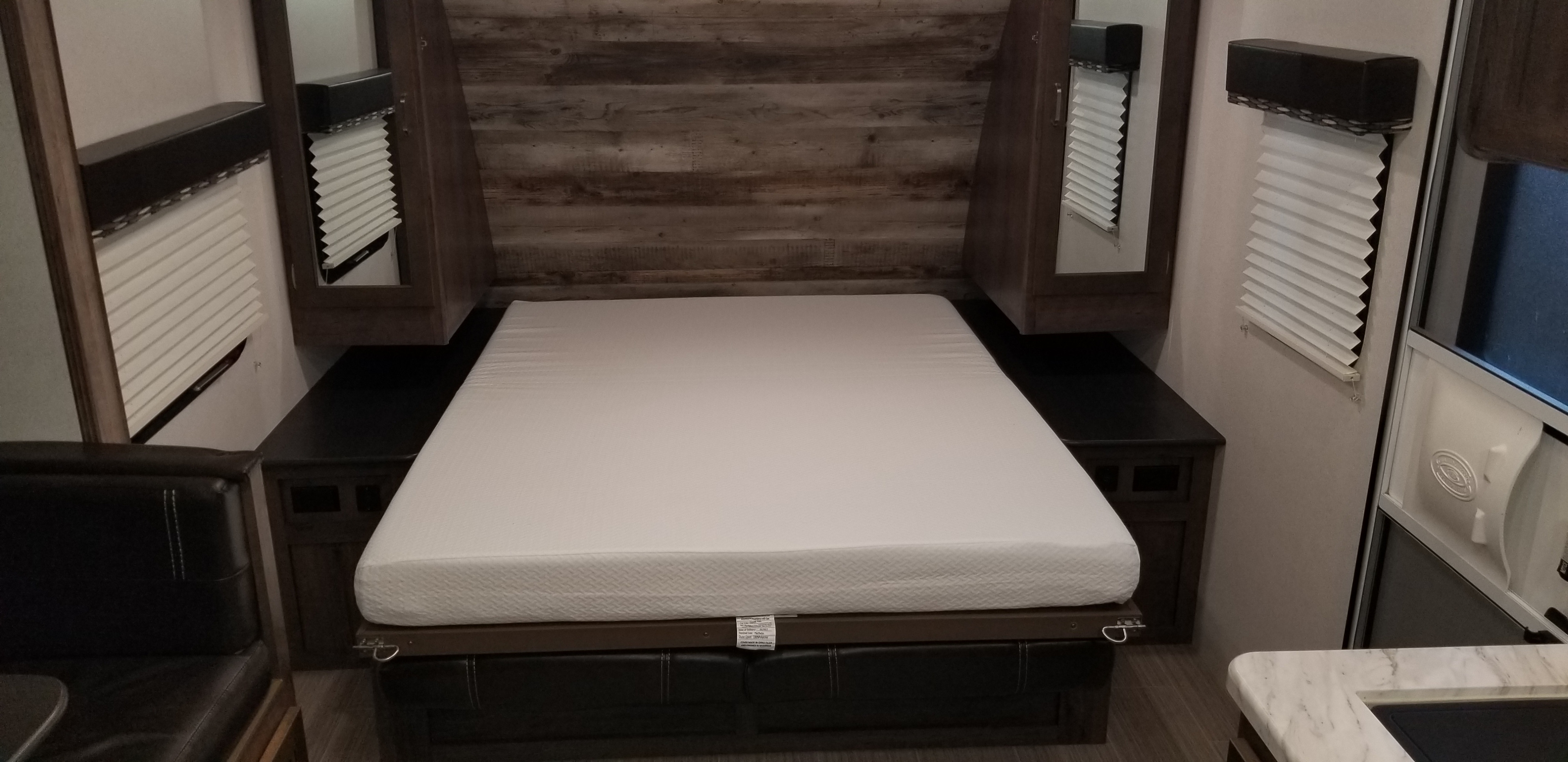 RV rental interior: Cozy bedroom featuring a space-saving Murphy bed, mirrored cabinets, and pleated blinds.. Keystone RV Passport 2019