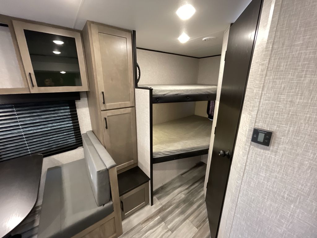 This RV rental interior features comfy bunk beds, a dinette, and ample storage, ideal for family camping trips.. Jayco 265BHS 2025