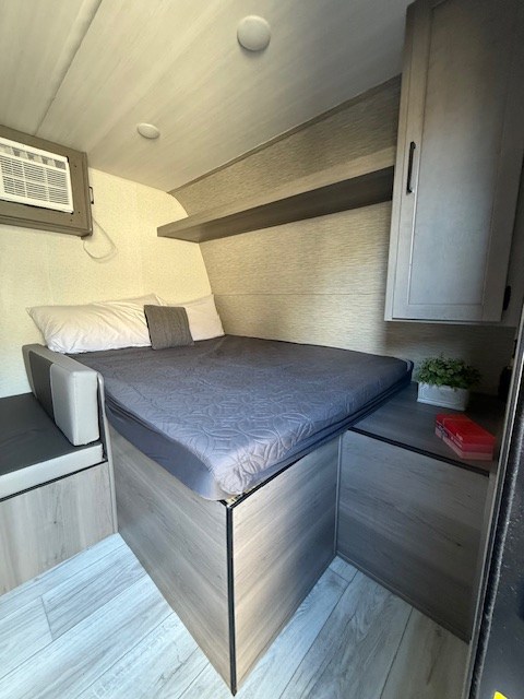Cozy RV rental bedroom with a comfy bed, AC unit, and smart storage. Ideal for compact adventures.. Keystone Hideout 175BH 2025