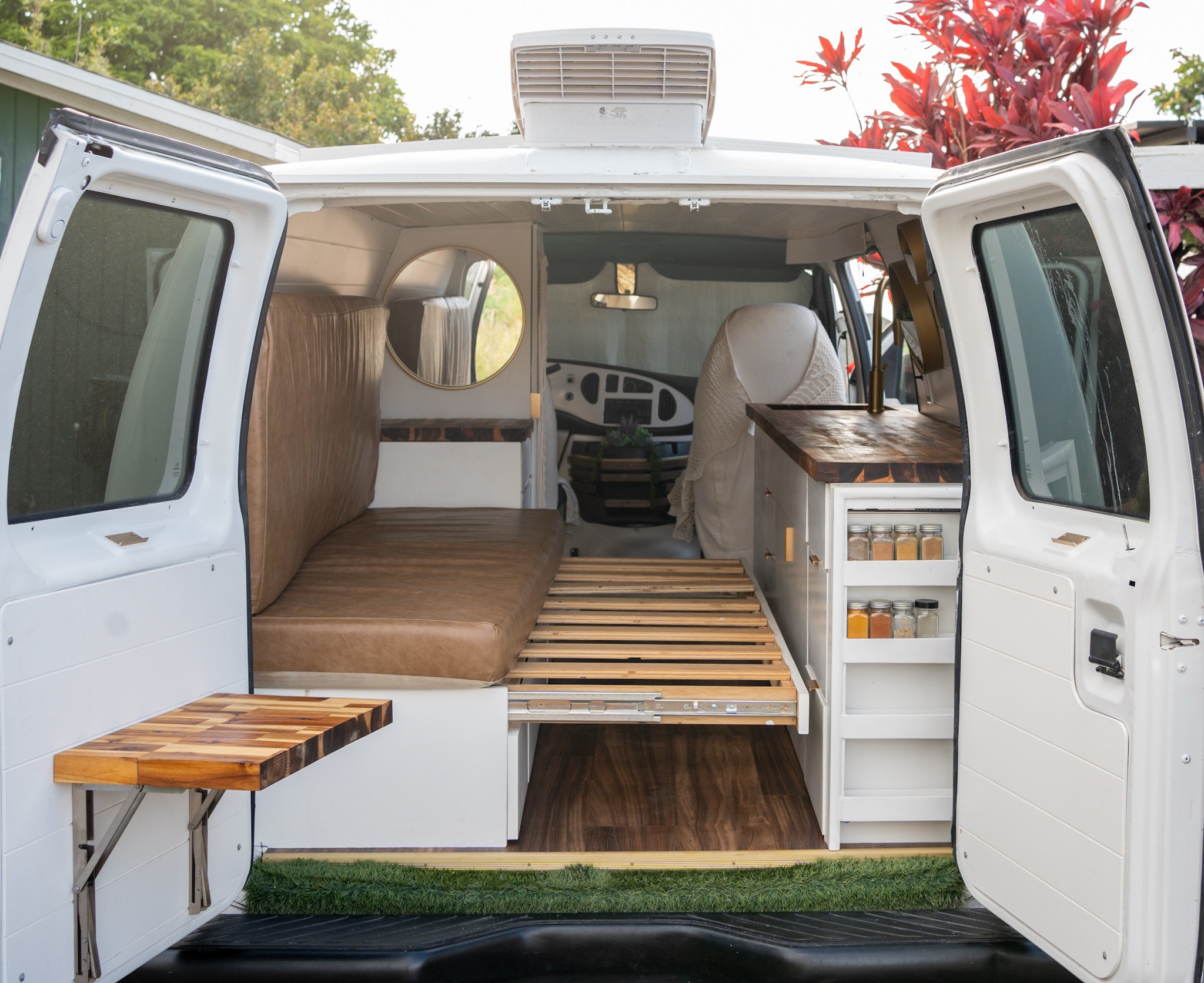 Inside an RV rental! This beautifully designed campervan features a compact kitchen, bed, and clever storage.. Ford Econoline 2006