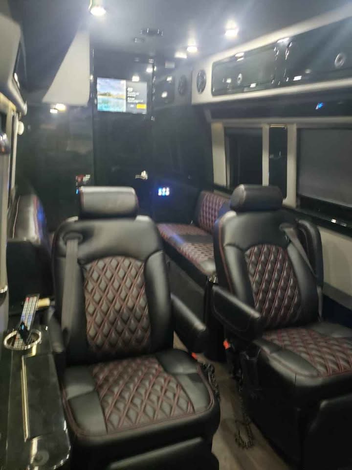 Plush black leather diamond-quilted seats and a TV fill this premium RV rental interior, ready for travel.. Midwest Automotive Designs Midwest Automotive Designs Class B 2016