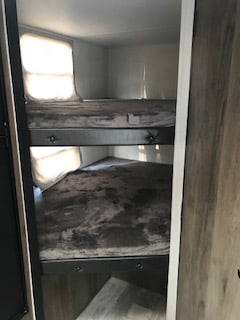 RV rental interior featuring two comfortable bunk beds with patterned bedding next to windows, ideal for travel.. Forest River Tracer 2020