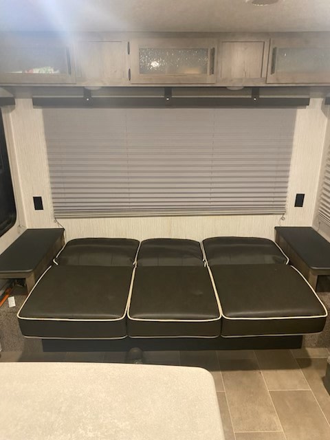 RV rental interior: Flat dinette bed setup with overhead cabinets & a large window blind. Perfect for camper sleeping.. FOREST RIVER 25RLC 2020