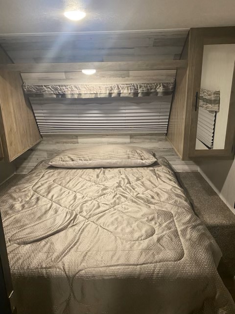 Cozy RV rental bedroom with a comfy bed, window, and storage. Perfect for a restful night.. FOREST RIVER 25RLC 2020