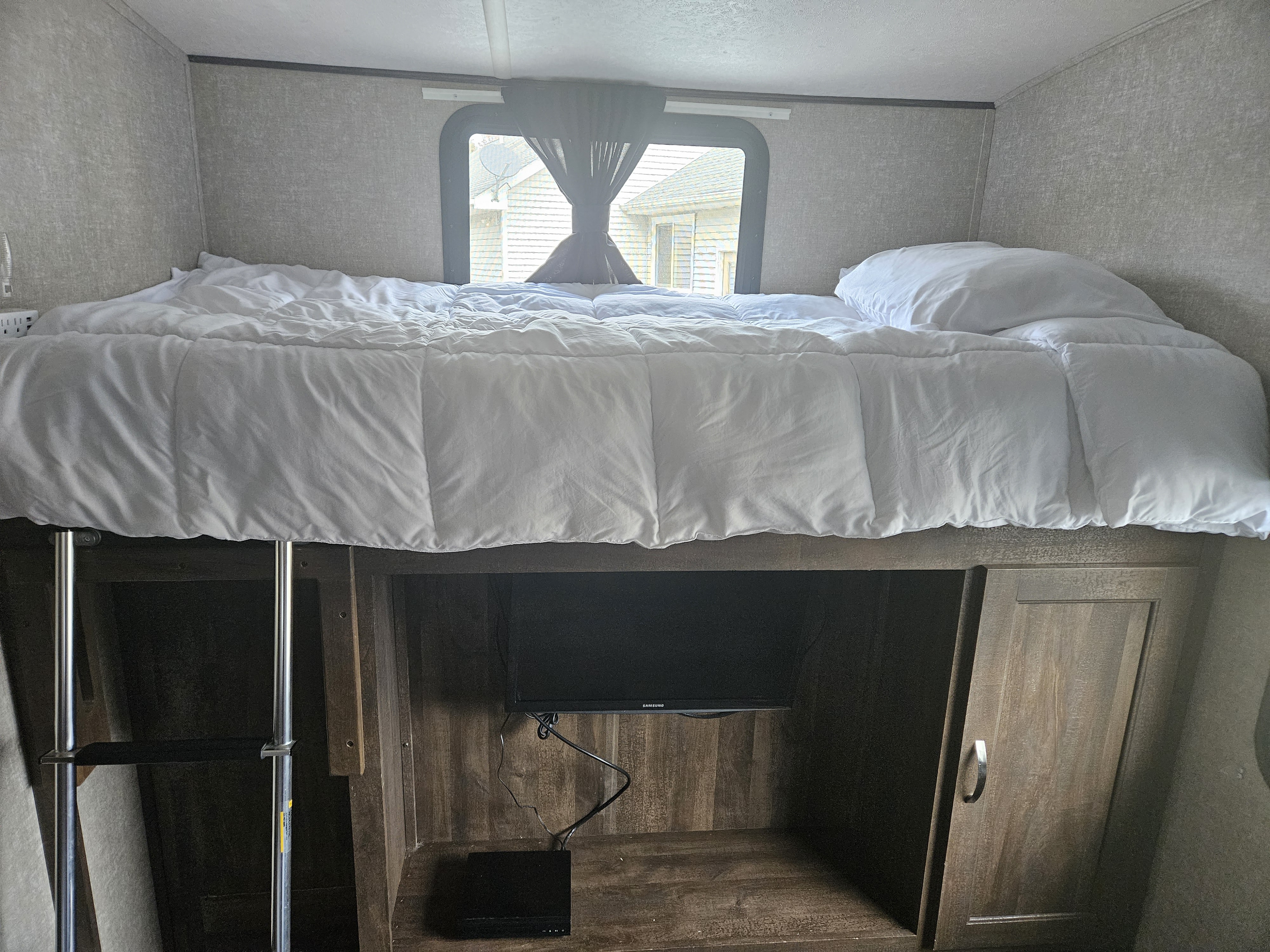 Cozy RV rental interior featuring a comfortable bunk bed, TV, and storage. Perfect for a camper's retreat.. Forest River Vibe 2018