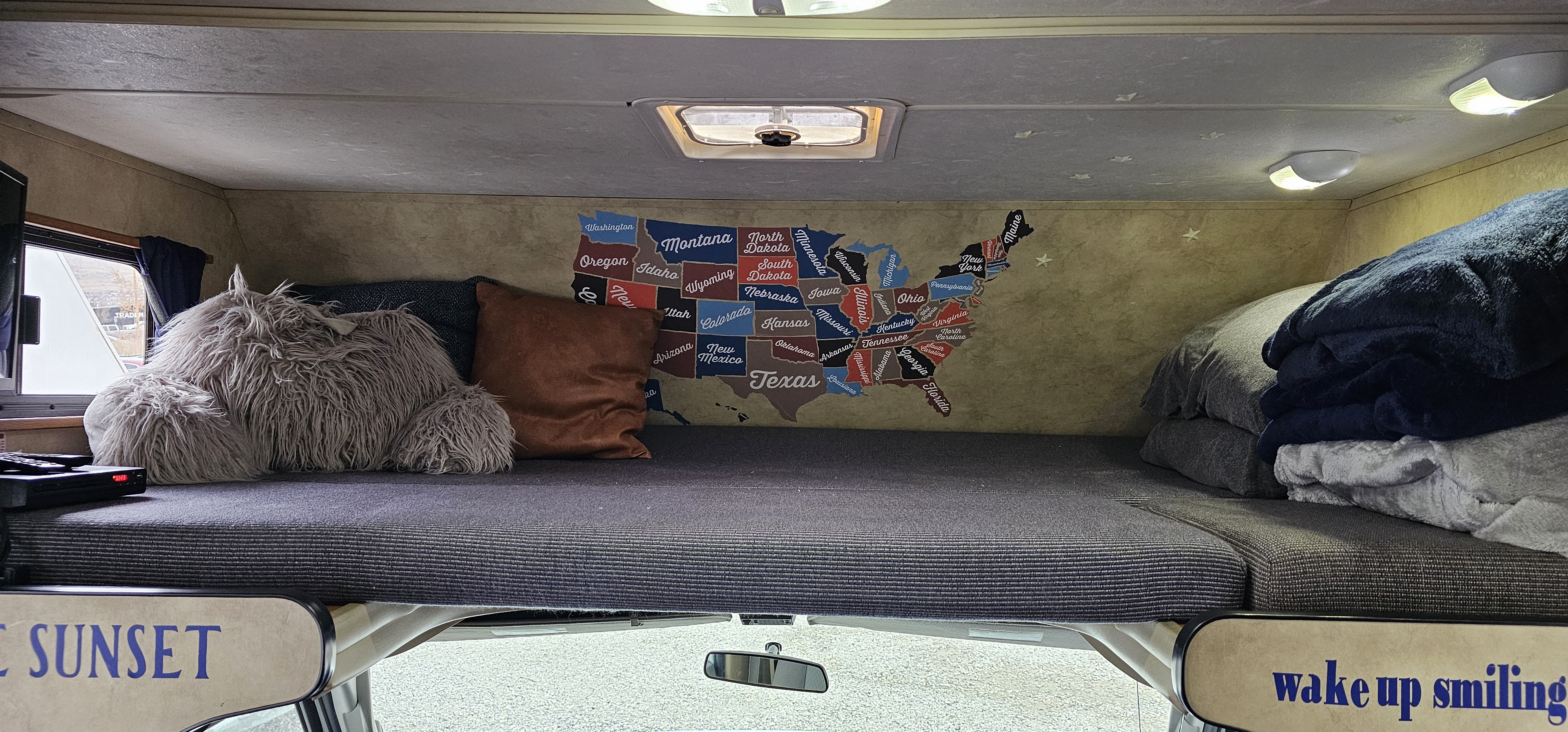 Enjoy a cozy night in this RV rental's bed, featuring a US map. Wake up smiling on your next road trip!. Thor Majestic 2014