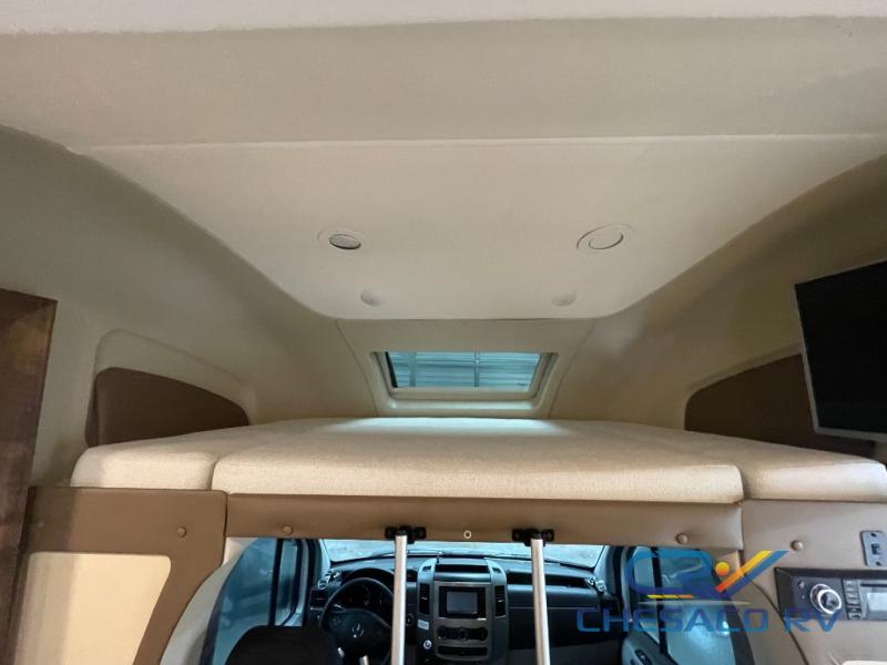 Inside this RV rental: a comfy overhead bunk bed, skylight, ceiling lights, and the driver's cab. Ready for travel.. Wayfarer Wayfarer Motorhome 2019