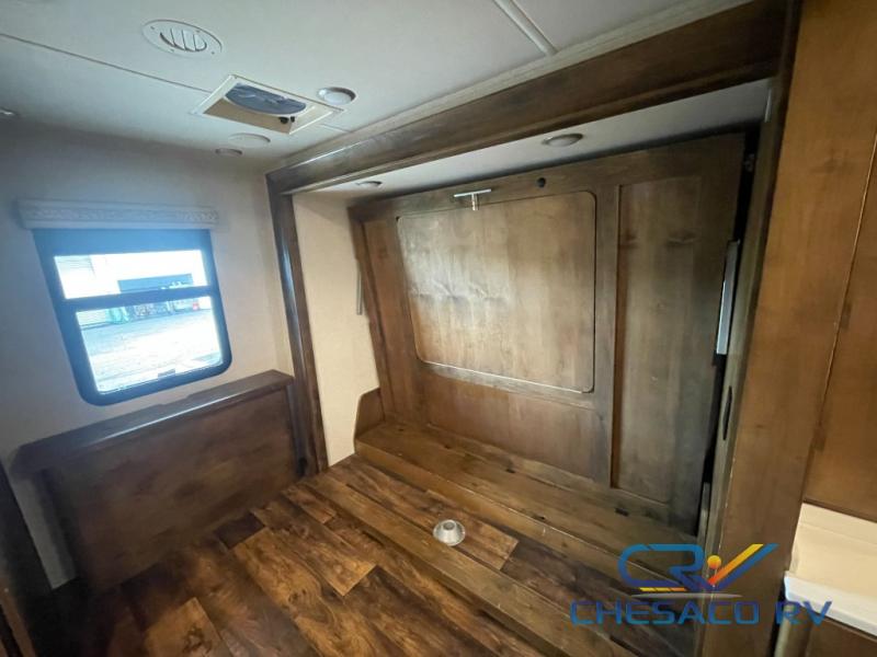 RV rental: Interior shows a versatile bedroom space with a folded Murphy bed, wood flooring, and a large window.. Wayfarer Wayfarer Motorhome 2019