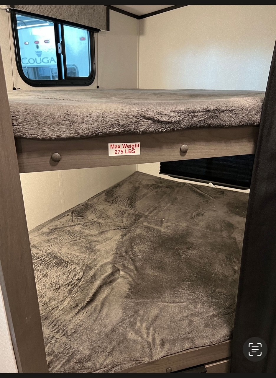 Inside an RV rental: two cozy bunk beds with soft grey blankets. Top bunk's max weight is 275 lbs.. Cruiser RV MPG Ultra Lite 2022