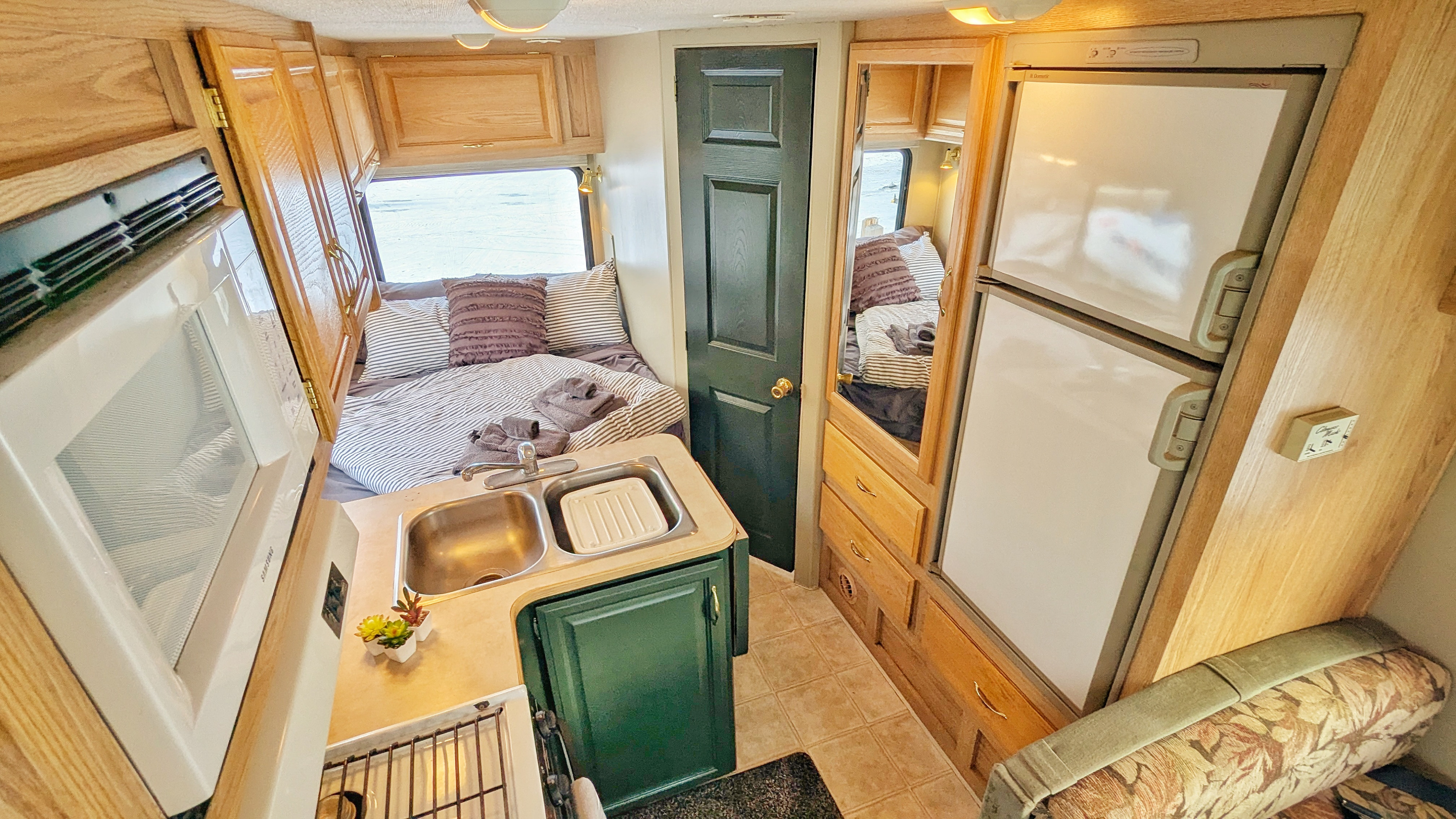 Step inside this RV rental showcasing a compact kitchen with sink/microwave, a cozy bed, and efficient living area with fridge.. Tioga Tioga Motorhome 2004