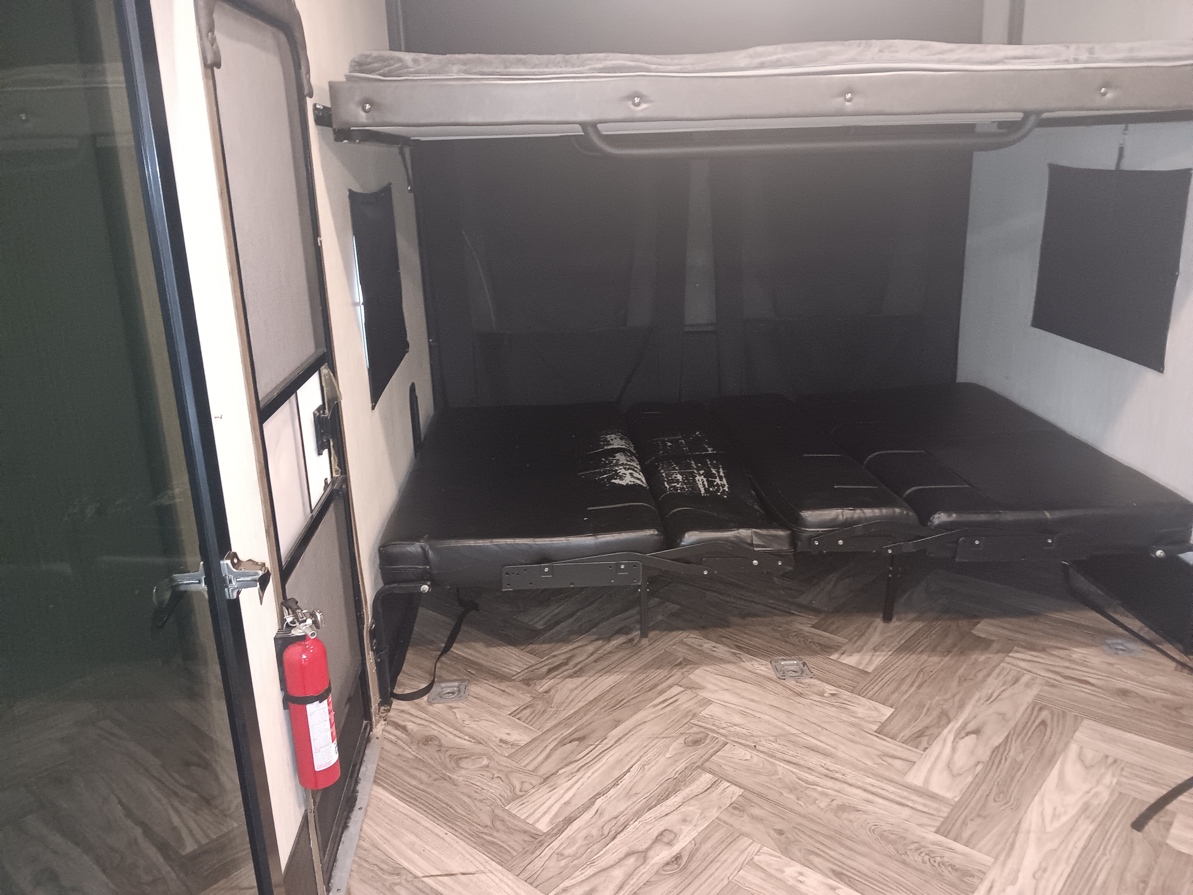 RV rental's adaptable interior featuring an overhead bunk bed, lower convertible seating/sleeping, and safety extinguisher.. Forest River 351 2020