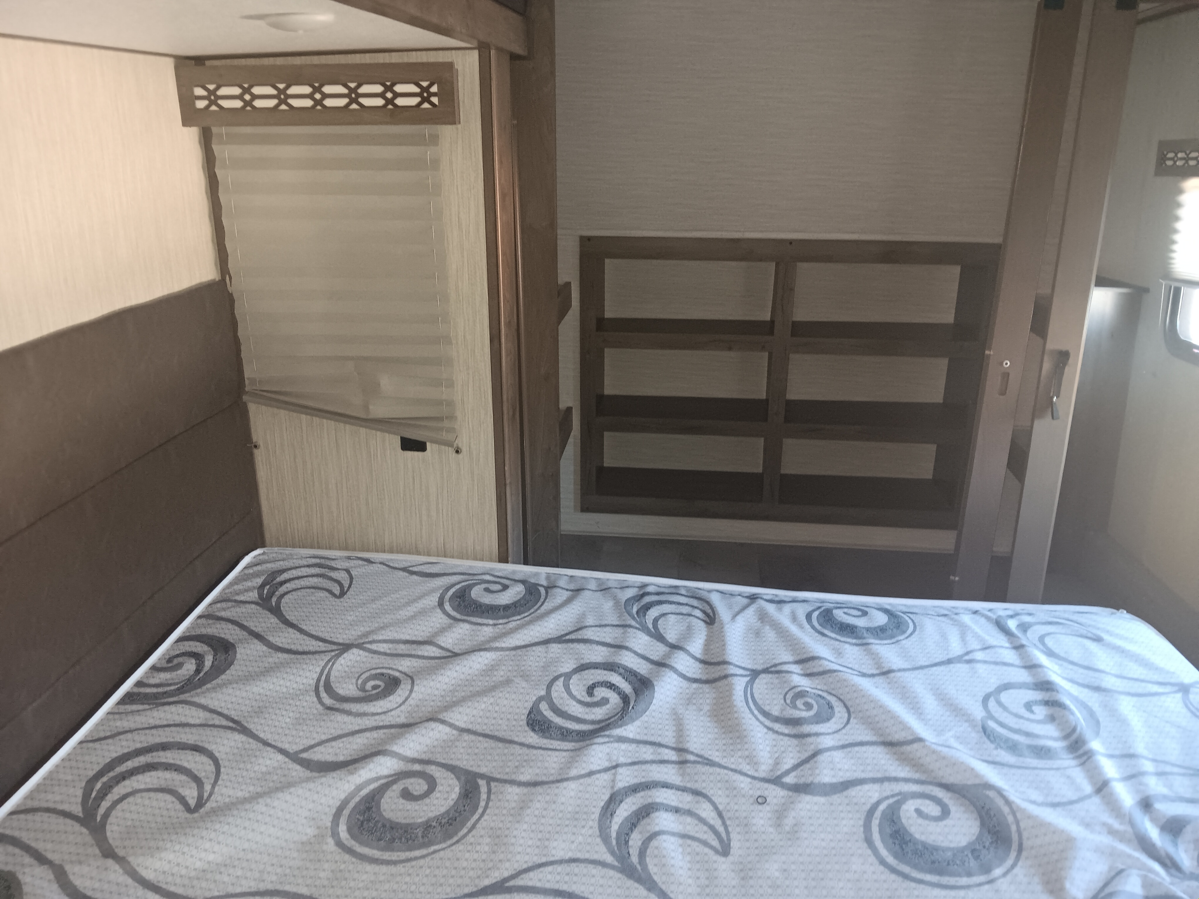 Cozy RV rental bedroom featuring a comfy mattress with a swirl pattern, bunk bed frame, and window blinds.. Forest River 351 2020