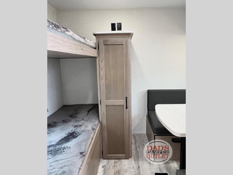 This RV rental interior offers comfort with bunk beds, a tall storage cabinet, and a dinette. Ideal for camper adventures and travel.. Gulf Stream Innsbruck 2024