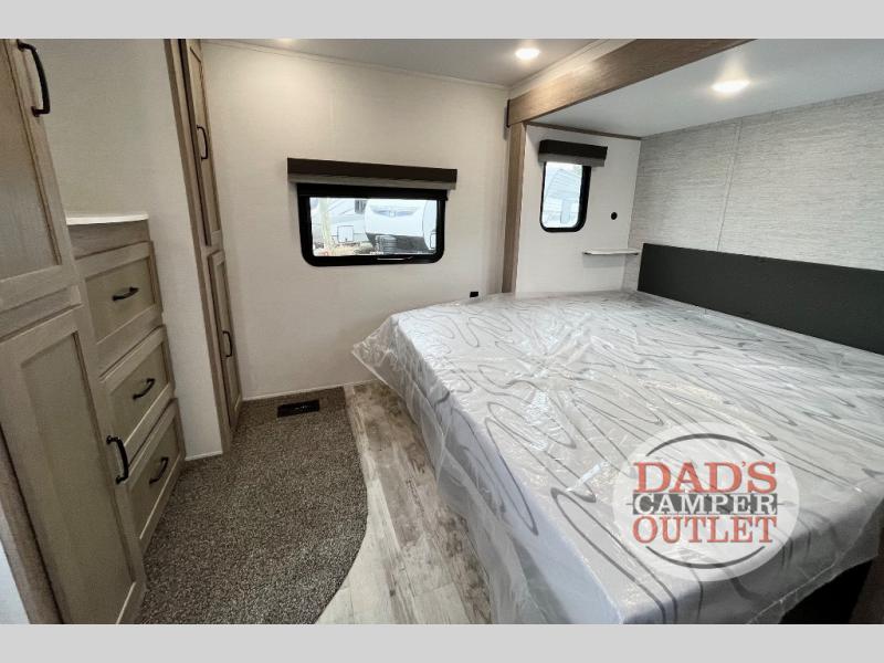 New RV bedroom with plastic-covered mattress, ample storage, and windows. Perfect for your next rv rental.. Gulf Stream Innsbruck 2024