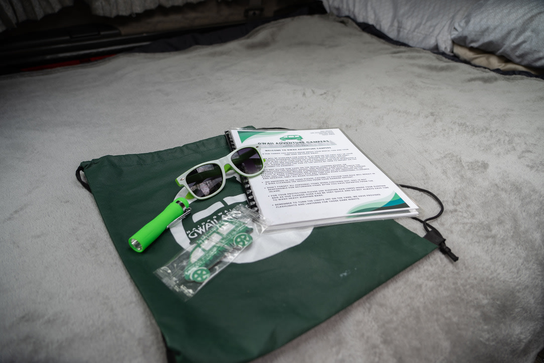 GWAII Adventure Campers RV rental welcome kit: bag, sunglasses, flashlight, and info on a cozy blanket.. mitsubishi delica 1997