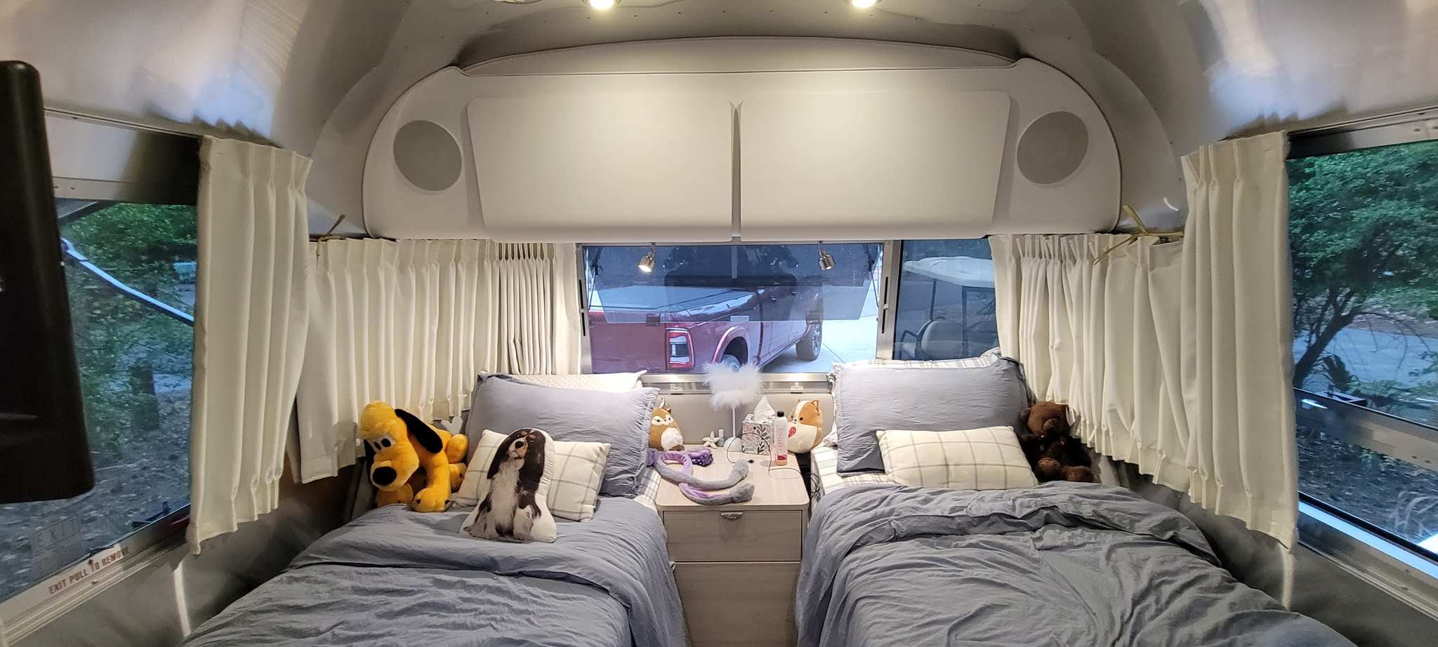 Cozy RV rental bedroom featuring twin beds, plush toys, and a peaceful view. Perfect for family adventures.. Airstream Globetrotter 2022