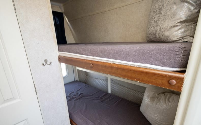 RV rental interior with cozy bunk beds. Upper and lower bunks provide comfortable sleeping for your camper adventure.. Keystone RV Outback 21RS 2004