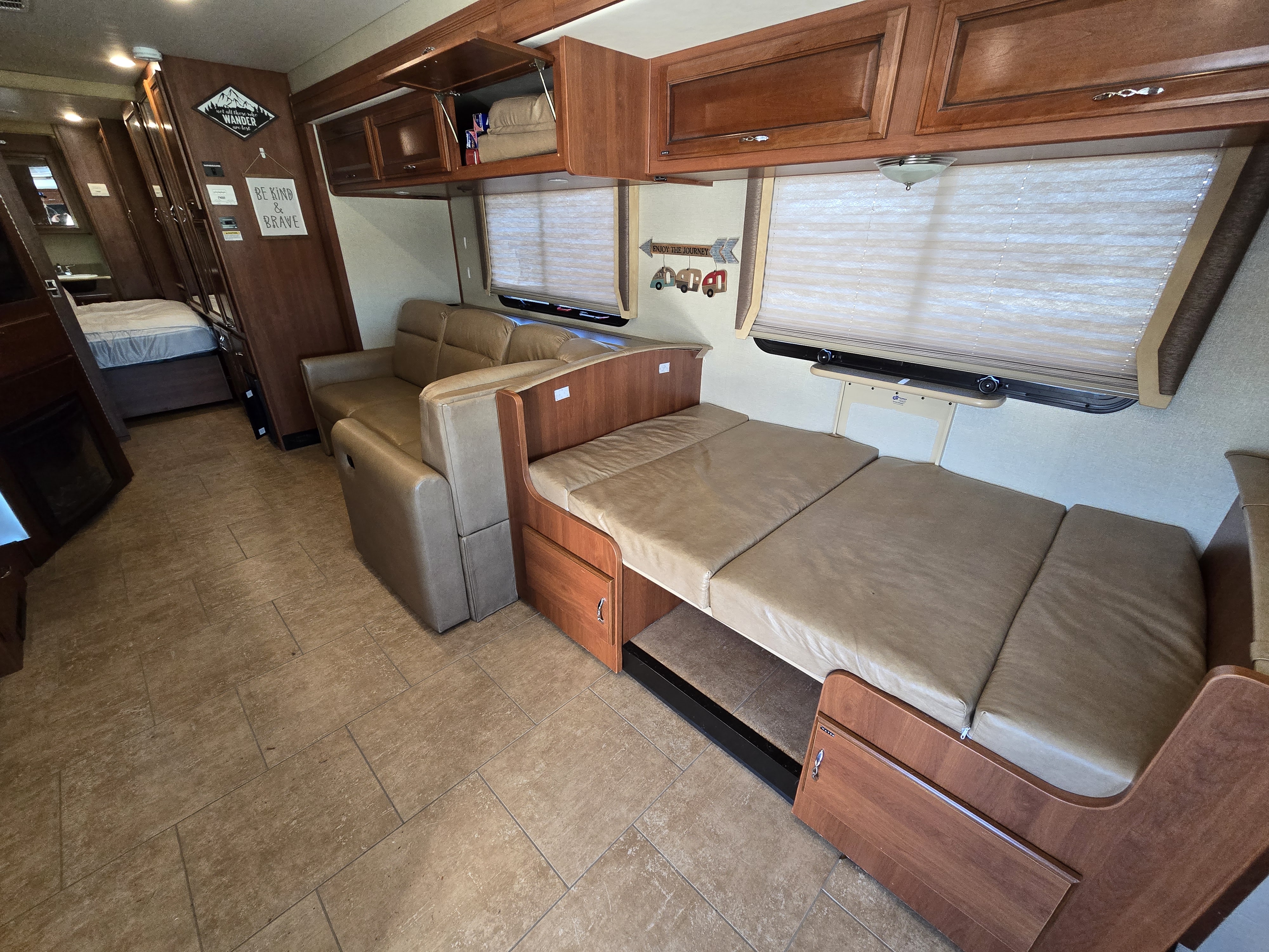 Spacious RV rental interior with comfy seating, a convertible bed, and warm wood finishes. Enjoy a comfortable living space!. Fleetwood Storm 35SK 2016