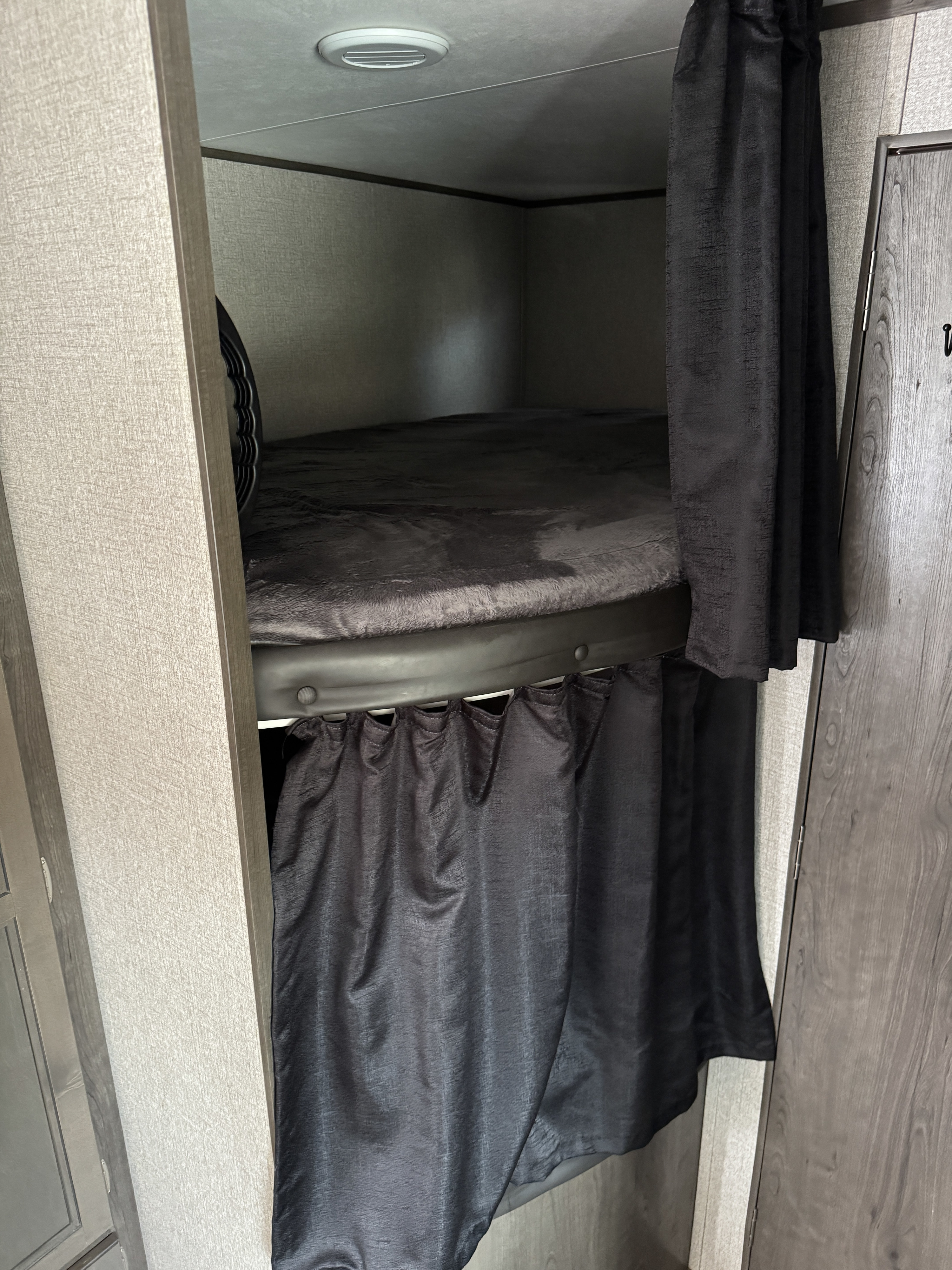 RV rental interior: Dark grey bunk beds with plush bedding and privacy curtains offer cozy sleeping spaces.. Jayco Jay Flight SLX 2021