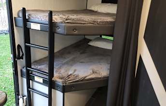 Inside an RV rental: view of stacked bunk beds with a ladder, providing cozy sleeping for camping trips.. Heartland Mallard 2022